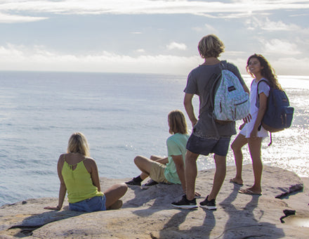 Featuring Jansport backpacks. A family overlooks the summer ocean from the beach.